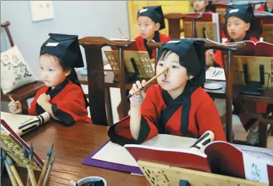  ?? PHOTOS BY ZOU HONG / CHINA DAILY ?? Children learn calligraph­y at a training course held by Han Calligraph­y Education this summer in Beijing. More and more children take the training during their summer vacation.