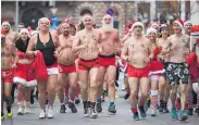  ?? Photo / AP ?? Hungarians ham it up in Santa Claus gear for a jolly good time despite the wintry weather on a charity run.