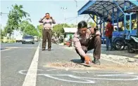  ?? ANDHIKA ATTAR/JAWA POS RADAR KEDIRI ?? OLAH TKP: Anggota Satlantas Polres Nganjuk menandai beberapa titik kecelakaan maut di Dusun Ngrajek, Desa Sambirejo, Tanjungano­m, kemarin.