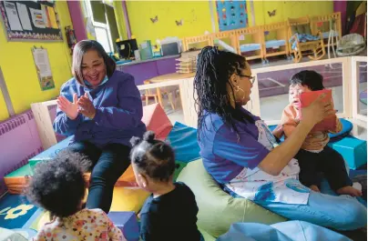  ?? VINCENT ALBAN/CHICAGO TRIBUNE PHOTOS ?? Debra Ward-Mitchell, assistant director of the Blanche Foxworthy Infant Care Center, left, and Jennifer Bennett Collins play with children last month at the center in Harvey. The center is one of only two programs in Illinois that provide day care for the children of teen parents pursing their high school education.