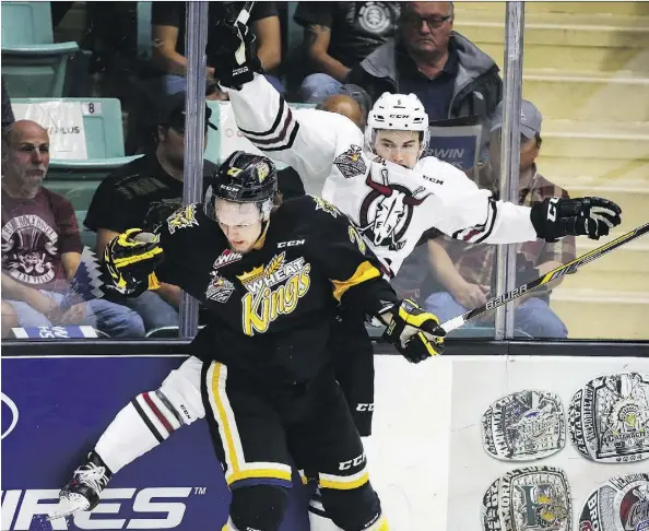  ?? JEFF MCINTOSH/THE CANADIAN PRESS ?? Brandon Wheat Kings’ Reid Duke, left, checks Red Deer Rebels’ Josh Mahura during the first period of their Memorial Cup round robin game in Red Deer, Wednesday. The Rebels won 2-1 in overtime to eliminate Brandon.