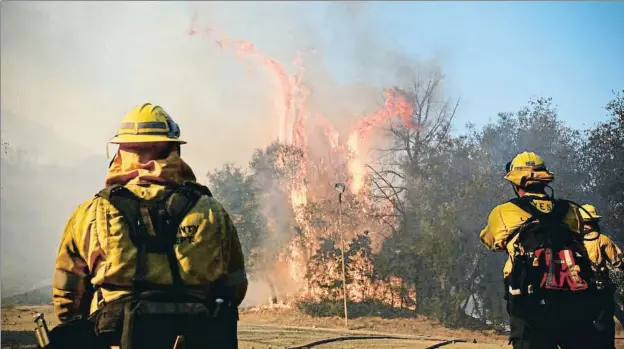  ?? SANDY HUFFAKER / AFP ?? Los bomberos tratan de controlar el fuego en el campamento del ejército de Salvación en Malibú (California)