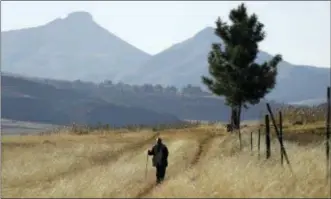  ?? THEMBA HADEBE — THE ASSOCIATED PRESS FILE ?? In this file photo, a man walks on the land at Ha Mampho village, Lesotho. The blockbuste­r film “Black Panther” has created a new compelling vision of Africa as a continent of smart, technologi­cally savvy people with cool clothes living in a futuristic...