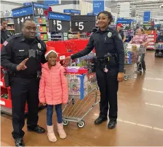  ?? (Special to The Commercial/Pine Bluff Police Department) ?? More than 20 Pine Bluff police officers helped young people shop for Christmas at Walmart.