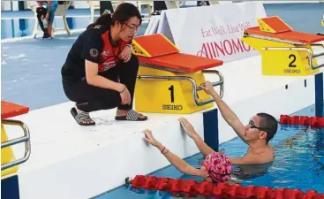  ?? — Photos: ART CHEN/The Star ?? Carmen and Yoong getting pointers from the national swimming coach Li Xin Xin.