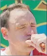  ?? AP PHOTO ?? Joey Chestnut eats two hot dogs at a time during the Nathan’s Annual Famous Internatio­nal Hot Dog Eating Contest on Tuesday in New York. Chestnut won, marking his 10th victory in the event.