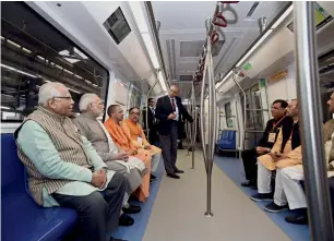  ?? PTI ?? Narendra Modi takes a ride in a Metro from the Botanical Garden Station to Okhla Bird Sanctuary along with Ram Naik, Yogi Adityanath and others after its inaugurati­on, in Noida, on Monday. —