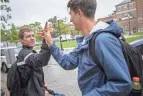  ?? ?? After finishing up at the library, Austin Bowman greets bandmate Sean O’brien before they head to lunch.