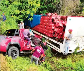  ?? (SUPPLIED PHOTO) ?? FIRST RESPONDERS pull out the two people inside the pick-up vehicle rammed by a 10-wheeler truck towards the ravine in Laguinding­an, Misamis Oriental, over the weekend. The crash left a woman killed and another seriously wounded.