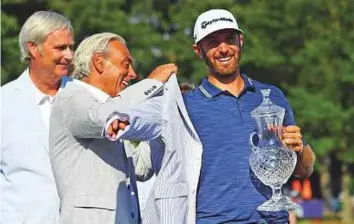  ?? USA Today Sports ?? Dustin Johnson is awarded with a Seersucker jacket after winning the FedEx St. Jude Classic tournament at TPC Southwind on Sunday.