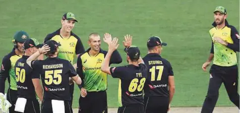  ?? AFP ?? Australia’s Ashton Agar (centre) celebrates with teammates after dismissing New Zealand’s Kane Williamson in the final of the Twenty20 tri-series at Eden Park in Auckland yesterday. Agar’s career-best T20 figures of three for 27 helped Australia triumph.