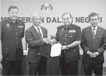  ?? - Bernama photo ?? Muhyiddin (second, left) presenting the letter of appointmen­t to Mazlan Masor (second, right) at a function yesterday.