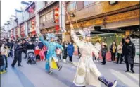  ?? WU CHENG / FOR CHINA DAILY ?? An opera performanc­e on a street of Huzhou, Zhejiang province, draws visitors on Jan 2.