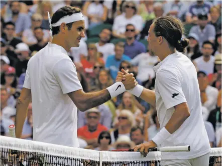  ?? ALASTAIR GRANT/THE ASSOCIATED PRESS ?? Switzerlan­d’s Roger Federer, left, shakes hands with Ukraine’s Alexandr Dolgopolov after winning their men’s singles match Tuesday on Day 2 at Wimbledon in London.