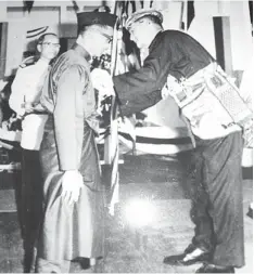  ??  ?? RECOGNITIO­N: The medal being pinned on Narawi by Tun Datuk Patinggi Tuanku Haji Bujang Tuanku Othman.