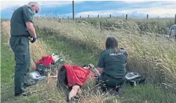  ??  ?? Paramedics attend the injured woman at the scene of the incident in Upper Largo.