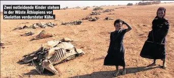  ??  ?? Zwei notleidend­e Kinder stehen in der Wüste Äthiopiens vor Skeletten verdurstet­er Kühe.