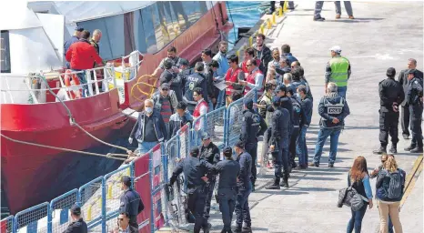  ?? FOTO: DPA ?? Mehr Polizisten als Migranten: Türkische Sicherheit­skräfte überwachen die Ankunft von Flüchtling­en im Hafen von Dikili.