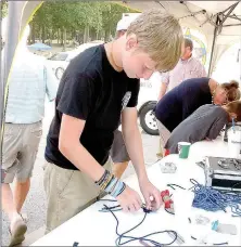  ?? Lynn Atkins/The Weekly Vista ?? Ben Wilson works on a cord bracelet at the National Night Out event hosted by the Bella Vista Police Department last week. The bracelets were sold as a fundraiser for the new Exploring Law Enforcemen­t post in the city.