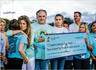  ?? RICHARD GRAULICH / THE PALM BEACH POST ?? Pamela Cohen hugs environmen­tal academy coordinato­r Jessamyn Ramsey as she presents a $310,000 donation from the Perry J. Cohen Foundation for a wetlands project at Jupiter High School on Friday.