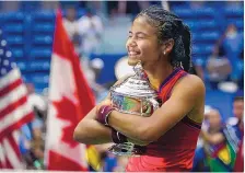  ?? ELISE AMENDOLA/ASSOCIATED PRESS ?? Emma Raducanu hugs the US Open championsh­ip trophy after defeating Leylah Fernandez in the women’s singles final of the US Open on Saturday in New York.