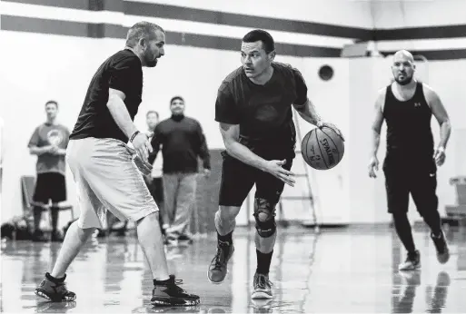  ?? Photos by Tim Warner / Contributo­r ?? The Rev. Preston Quintela drives to the basket defended by Michael Garcia during a practice for the Priests Versus Seminarian­s game.