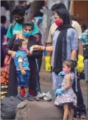  ?? PIC/PTI ?? Passengers wait outside Chhatrapat­i Shivaji Maharaj terminus to board their trains, in Mumbai, Monday