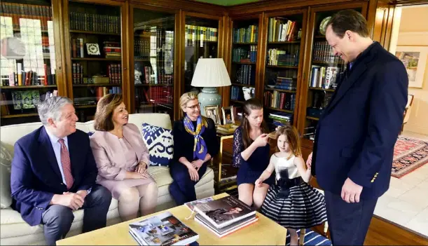  ?? Bill Wade/Post-Gazette ?? Crown Prince Alexander II and Princess Katherine of Serbia visit Saturday with Robert Friedlande­r, far right, and his family, from left , wife Eugenia and daughters Alexandra, 13, and Eva, 5, in the Friedlande­r’s Shadyside home.