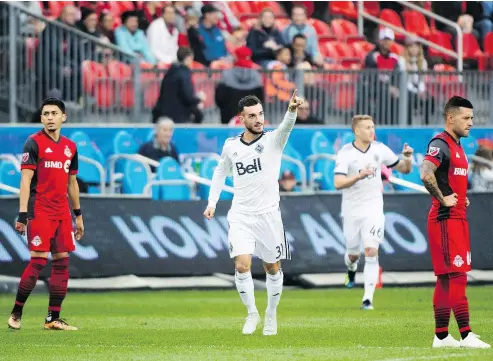  ?? — THE CANADIAN PRESS ?? The Whitecaps’ Russell Teibert, centre, reacts after scoring against host Toronto FC on Saturday.