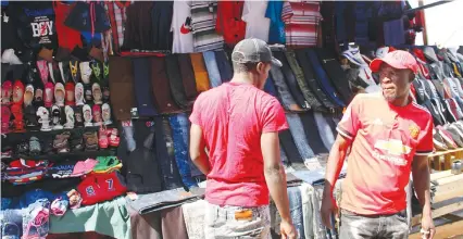  ?? — (Picture by Nicholas Bakili) ?? Takura Mudhe (right) negotiates with a customer at the recently opened flea market along Julius Nyerere in Harare. This comes after vendors were chased away from the Central Business District to decongest the city.