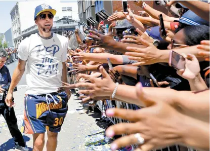  ??  ?? El ídolo Stephen Curry bajó del camión y saludó a decenas de los fans que acompañaro­n al equipo
