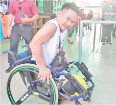  ??  ?? Francis showing how hard it is to travel on a wheelchair at the Donggongon town in Penampang which lacks OKU-friendly facilities.