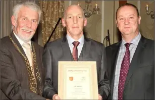  ??  ?? Paul Brennan receives a scroll on behalf of his late father Joe, a selector in 1967, from Mayor Jim Moore and Killian Duignan, club chairman.