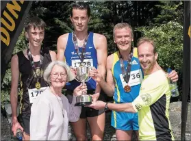  ??  ?? Runner-up Jack Boylan of Dunleer AC (black singlet), winner of the men’s race Paddy Hamilton and third-placed Shane Healy receive their prizes after the Sean Carrie/Ollie Brennan Memorial Road Race in Dunleer.