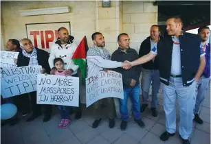  ?? (Mussa Qawasma/Reuters) ?? A PALESTINIA­N man shakes hands with a TIPH member in Hebron last week.