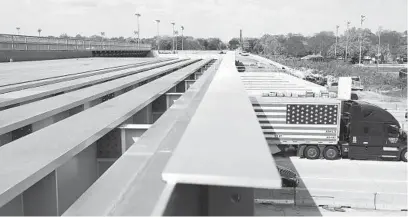  ??  ?? A truck drives the Tri-State Tollway below the new beams for a BNSF railroad bridge near Hinsdale on Friday. Trains are currently using a temporary bridge next to this new expansion.