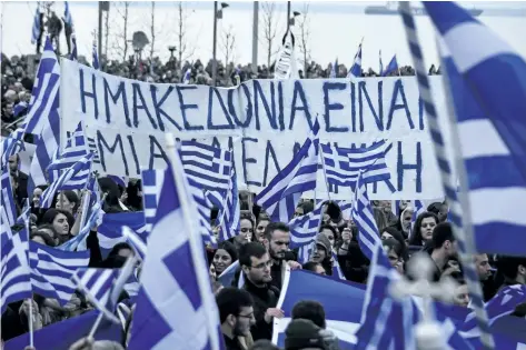  ?? GIANNIS PAPANIKOS/THE ASSOCIATED PRESS ?? Greek protesters wave flags and a banner reading “Macedonia is one and is Greek”, during a rally against the use of the term “Macedonia” for the northern neighbouri­ng country’s name, at the northern Greek city of Thessaloni­ki on Sunday.