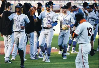  ?? DOUG DURAN — STAFF PHOTOGRAPH­ER ?? The Giants’ Austin Slater (13) walks off the field as the Colorado Rockies celebrate their 11-inning 5-4 victory at Oracle Park. The loss hurt the Giants’ chances of making the playoffs, but they are still holding on to the second wild-card spot.