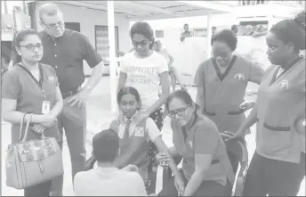  ??  ?? Tracey Waheeda along with her 14-year-old daughter (seated) being comforted by her co-workers and others.