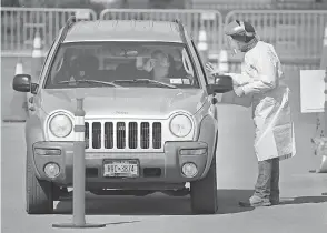  ?? JAMIE GERMANO/ USA TODAY NETWORK ?? A driver gets tested for coronaviru­s Tuesday at a drive- thru site in a Walmart parking lot in Rochester, N. Y.