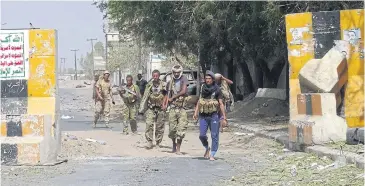  ?? AFP ?? Yemeni pro-government forces gather on the eastern outskirts of Hodeida on Saturday as they continue to battle for control of the city from Houthi rebels.