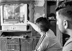  ??  ?? Palestinia­ns watch on TV the signing of a reconcilia­tion deal in Cairo between rival Palestinia­n factions Hamas and Fatah in Rafah in the southern Gaza Strip. — AFP photo