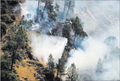  ?? Andrew Kuhn ?? The Associated Press Crews battle the Ferguson Fire along steep terrain Saturday behind the Redbud Lodge along state Route 140 near El Portal, Calif.