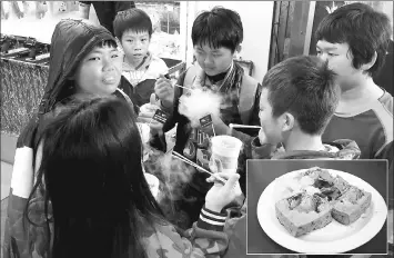  ??  ?? Children eat ice cream frozen with liquid nitrogen - and blow the sublimed gas out their noses for fun. • (Inset) Customers can get stinky tofu with a side of pickled cabbage at the Linjiang Street Night Market. — Washington Post photos