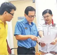  ??  ?? (From left) Chin, Lee and Dr Wong look at reports on cancer patients treated at Miri Hospital and SGH.