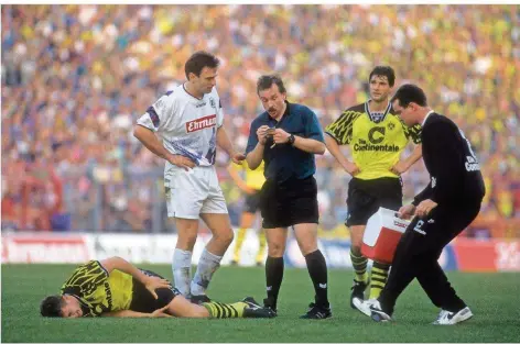  ?? FOTO: IMAGO ?? Schiedsric­hter Volkmar Fischer (Zweiter von links) verwarnt Jens Nowotny vom Karlsruher SC (links) nach einem Foul an Lars Ricken von Borussia Dortmund (am Boden). Die Bundesliga-Partie im Oktober 1994 zwischen dem KSC und dem BVB endete 0:0. Fischer leitete 48 Erst- und Zweitliga-Spiele.