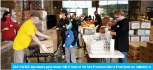  ?? — AFP ?? SAN RAFAEI: Volunteers pack boxes full of food at the San Francisco-Marin Food Bank on Saturday in San Rafael, California.