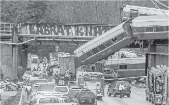  ?? PETER HALEY, THE NEWS TRIBUNE VIA AP ?? The Amtrak train making the first run along a faster new route hurtled off an overpass Monday and spilled some of its cars onto the highway below.