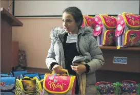  ?? ?? A girl selects her new backpack which she will use when she starts school.