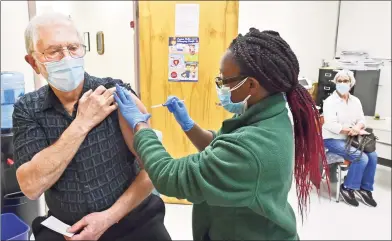  ?? Peter Hvizdak / Hearst Connecticu­t Media ?? William Stark, 72, of Wallingfor­d, gets vaccinated by nurse Leshawna Murrell at the New Haven Public Health Department Friday. At top, Patricia Stark, 69, gets the vaccine from nurse Maxine Jones Singleton.